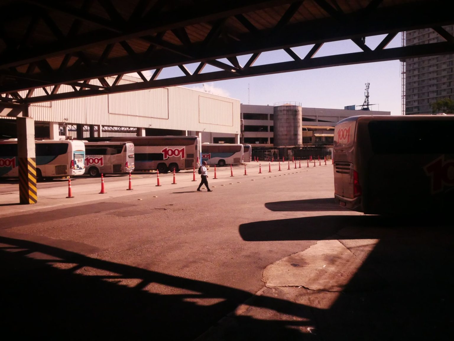 Terminal rodoviário movimentado no Rio de Janeiro, com ônibus e passageiros em circulação.