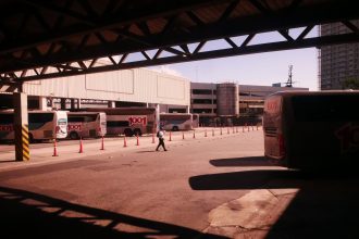 Terminal rodoviário movimentado no Rio de Janeiro, com ônibus e passageiros em circulação.
