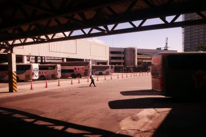 Terminal rodoviário movimentado no Rio de Janeiro, com ônibus e passageiros em circulação.
