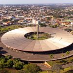 Vista aérea de um terminal rodoviário com ônibus, edifícios e a paisagem urbana ao redor