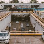 Ônibus e carros circulam por um viaduto movimentado em uma área urbana.